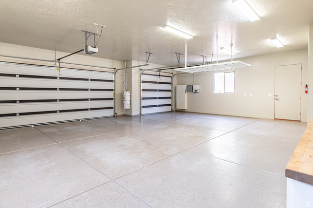322 340 E Street Ivins, UT 84738 - Photo 47 of 61 Spacious garage featuring two sectional garage doors with automatic openers, an epoxy-coated concrete floor, ample overhead lighting, and built-in overhead storage racks