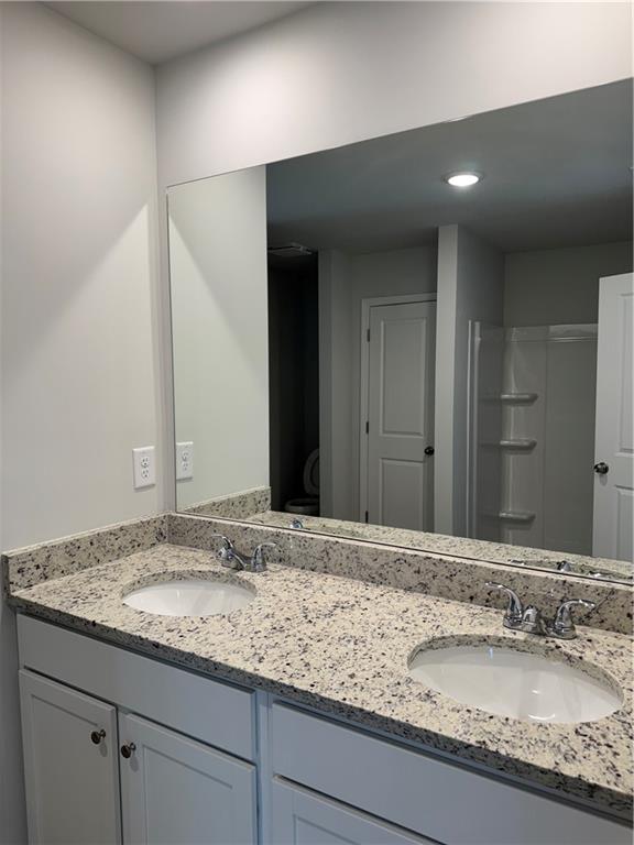11067 Suria Drive Covington, GA 30014 - Photo 16 of 22 a bathroom with a granite countertop sink and a mirror