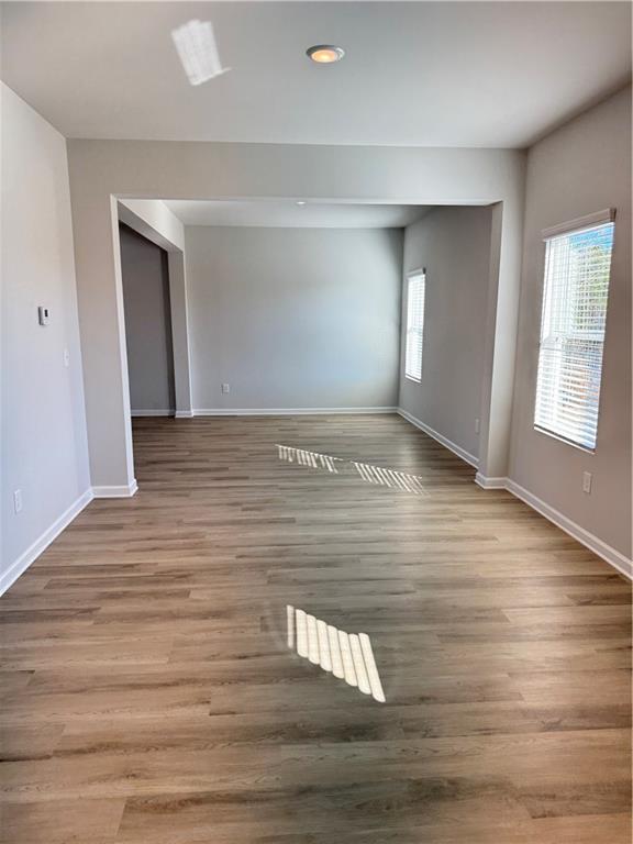 11067 Suria Drive Covington, GA 30014 - Photo 6 of 22 a view of an empty room with wooden floor and window