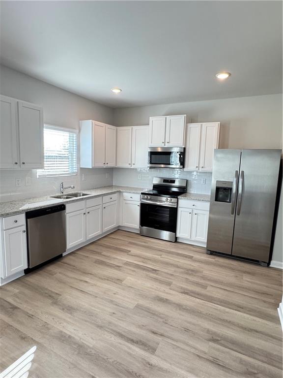 11067 Suria Drive Covington, GA 30014 - Photo 7 of 22 a large kitchen with cabinets stainless steel appliances a sink and a window