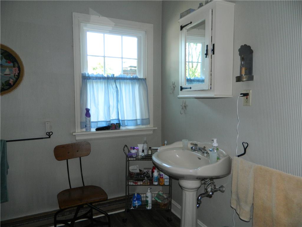 2130 Huntington Street Bethlehem, PA 18017 - Photo 23 of 23 A well-lit washroom features a pedestal sink, framed window, and practical wall storage.