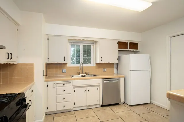 a kitchen with a sink a stove a refrigerator and cabinets