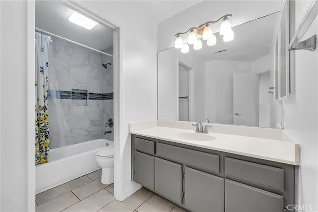 a bathroom with a bathtub shower sink vanity and toilet