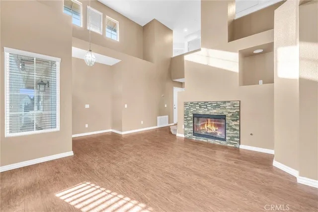 a view of an empty room with a fireplace and a window