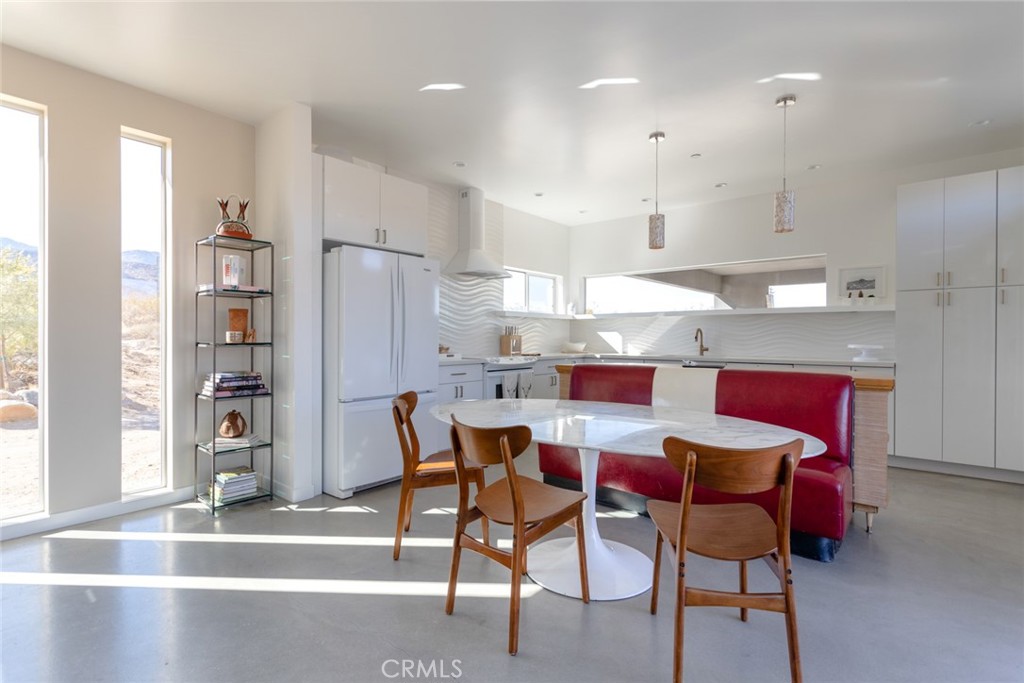 7802 Quail Springs Road Joshua Tree, CA 92252 - Photo 7 of 46 a kitchen with a dining table chairs and refrigerator
