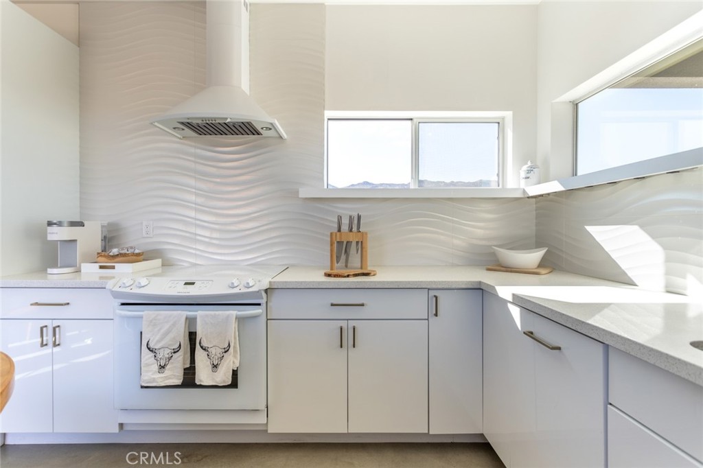 7802 Quail Springs Road Joshua Tree, CA 92252 - Photo 10 of 46 a view of cabinets a sink and a potted plant sitting on a granite counter top