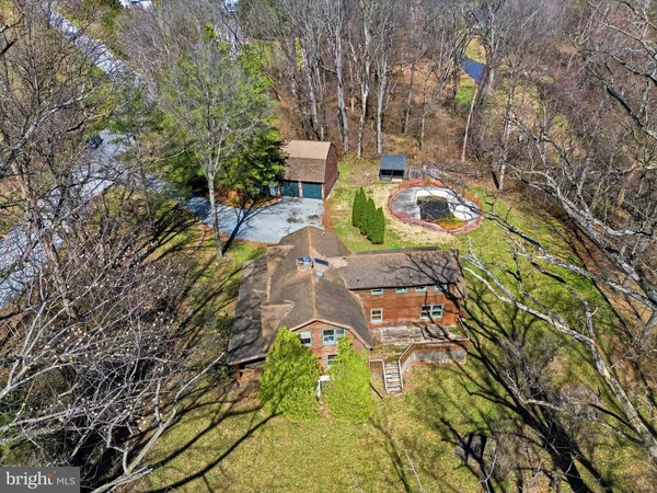 an aerial view of a house with a yard and trees