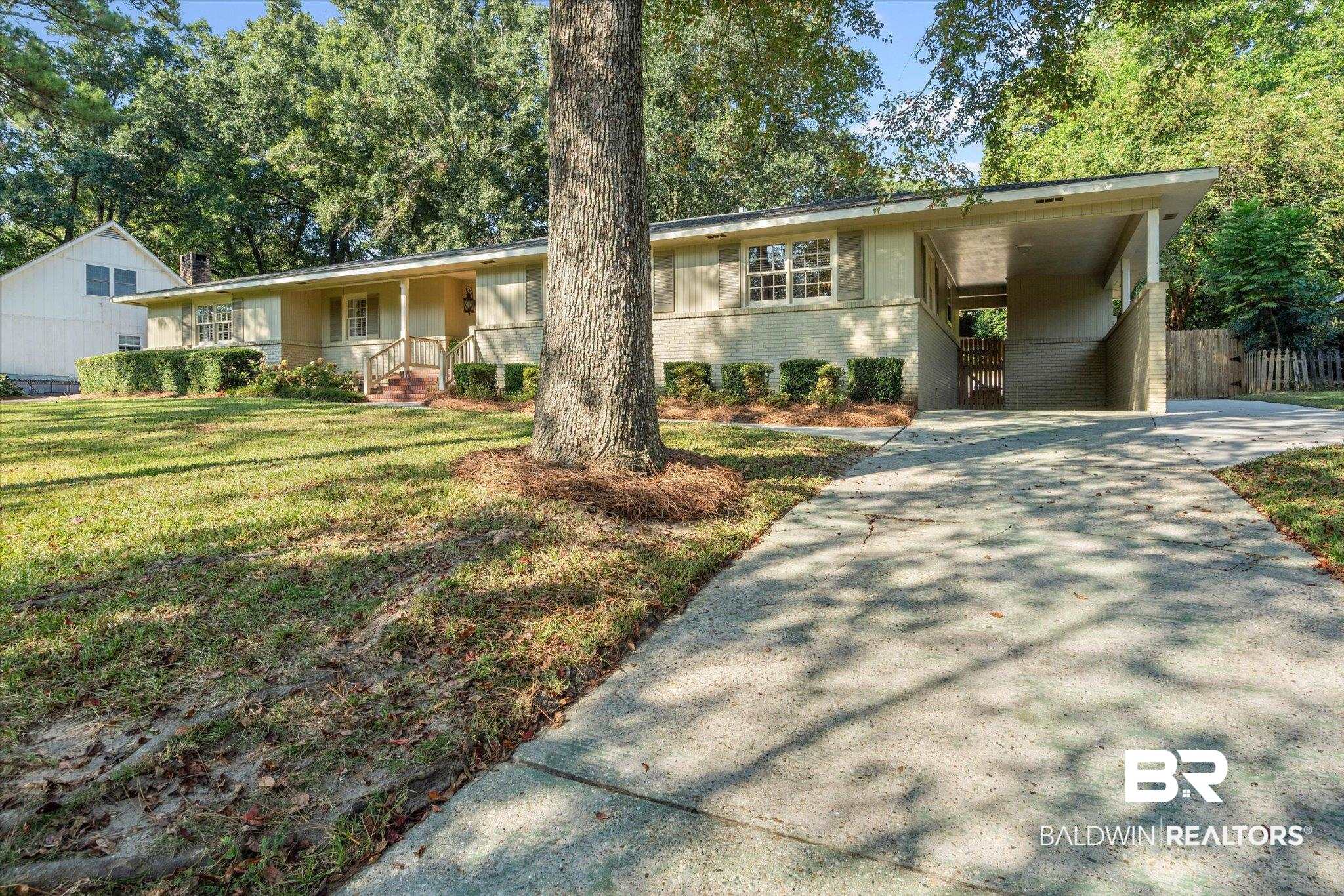 313 Brawood Drive Mobile, AL 36608 - Photo 30 of 32 View of front facade featuring a carport, brick siding, concrete driveway, a porch, and a front yard