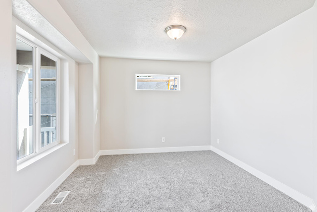 387 Slant Road, Unit 30 Spanish Fork, UT 84660 - Photo 4 of 25 Room featuring light grey carpeting, white baseboards, and neutral wall paint