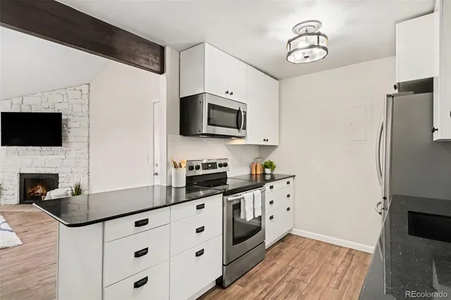 a kitchen with granite countertop a refrigerator stove and microwave