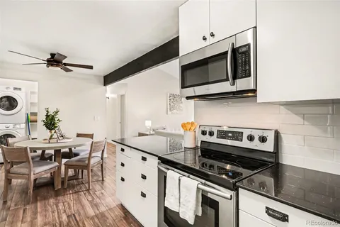 a kitchen with stainless steel appliances a stove a microwave and white cabinets