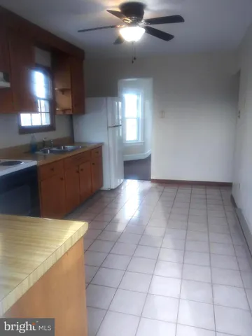 a large kitchen with granite countertop a stove a sink and a microwave