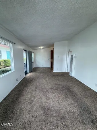 a view of a big room with windows and chandelier fan