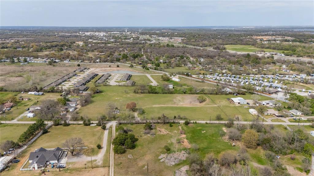 924 Fox Lane Azle, TX 76020 - Photo 3 of 8 Expansive land parcel featuring existing residential structures, paved roads, and scattered mature trees