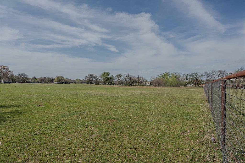 924 Fox Lane Azle, TX 76020 - Photo 6 of 8 Expansive open field featuring a wire fence with metal posts, green grass, and distant trees