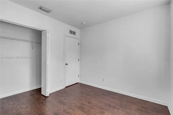 a view of an empty room with wooden floor