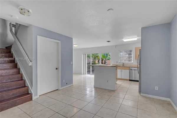 a view of a kitchen with refrigerator and white cabinets