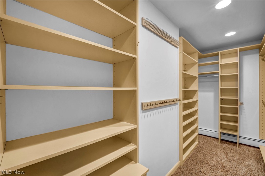 6845 Liberty Road Solon, OH 44139 - Photo 26 of 47 Expansive walk-in closet featuring extensive built-in shelving, hanging rods, light-toned wood-finish cabinetry, recessed ceiling lighting, and carpet flooring