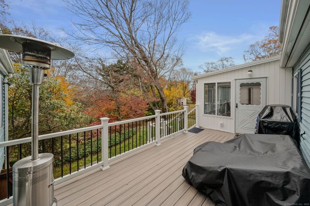 a view of a house with wooden deck and furniture