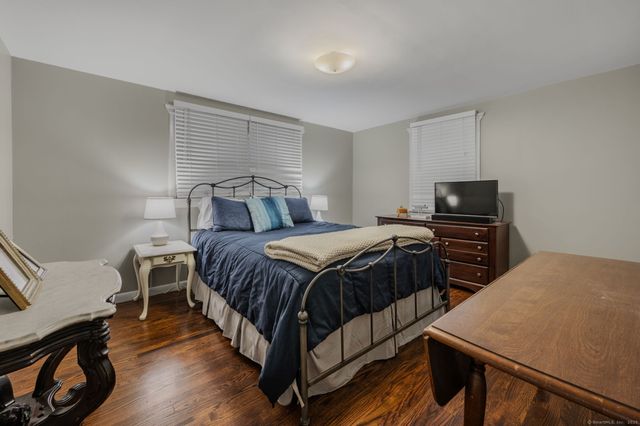 a bedroom with a bed and wooden floor