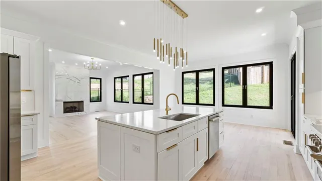 a open kitchen with white cabinets and wooden floor