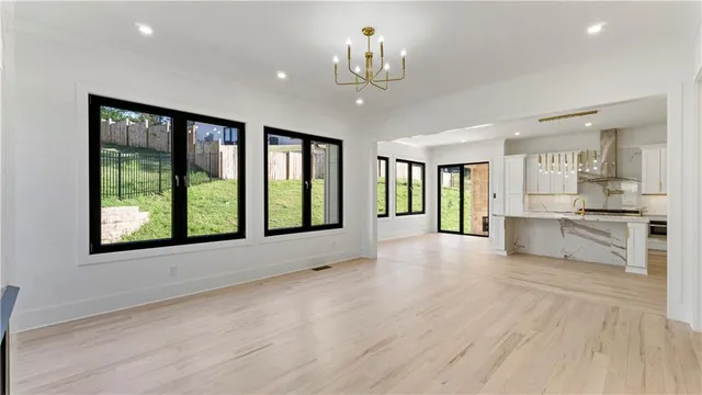 a kitchen with kitchen island granite countertop a stove a sink and a white cabinets