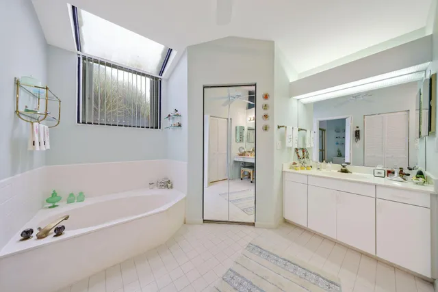 a spacious bathroom with a tub sink and mirror