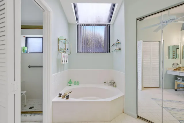 a white bath tub sitting in a bathroom and mirror