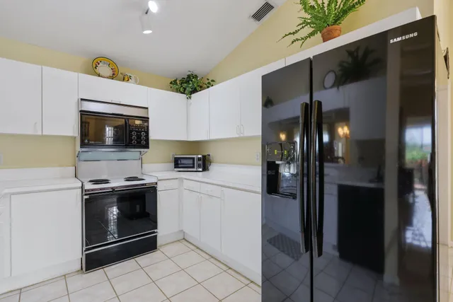 a kitchen with stainless steel appliances kitchen island a refrigerator and a stove top oven