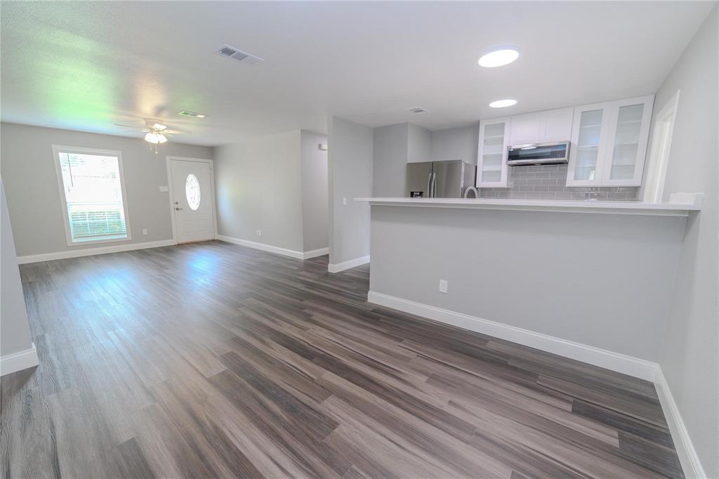 809 Wilcox Street McKinney, TX 75069 - Photo 5 of 26 Unfurnished living room featuring dark wood-type flooring and ceiling fan