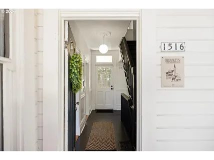 a view of a hallway with wooden floor and a bathroom