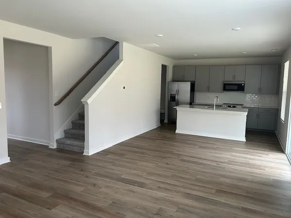 a view of a kitchen with wooden floor and electronic appliances