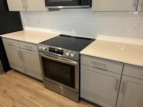 a stove top oven sitting inside of a kitchen
