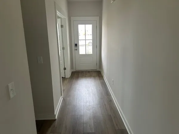 a view of a hallway with wooden floor and a window