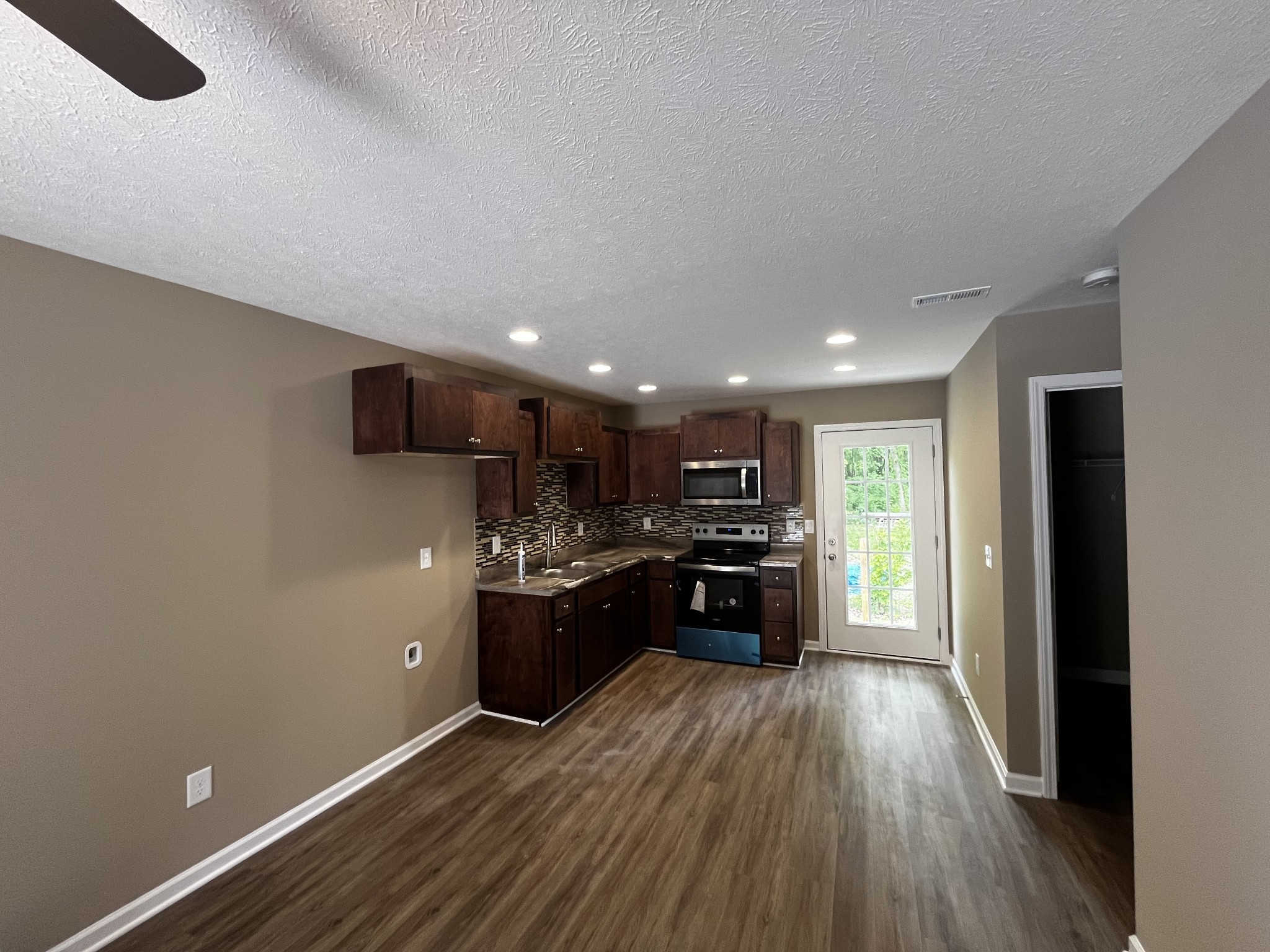 209 Thomas Street Tullahoma, TN 37388 - Photo 3 of 8 a view of kitchen with refrigerator stove and wooden floor