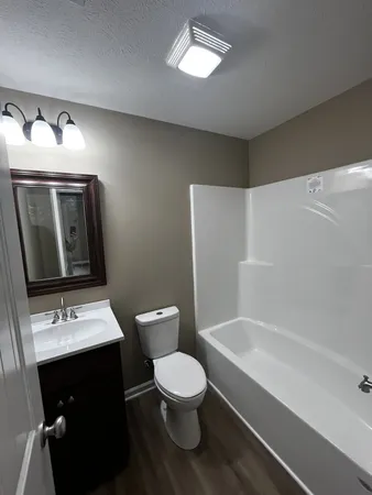a bathroom with a toilet sink and mirror