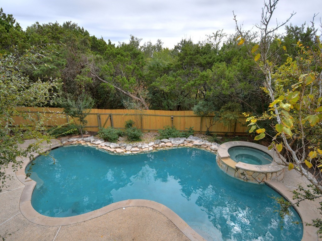 a view of a swimming pool in he middle of the green field