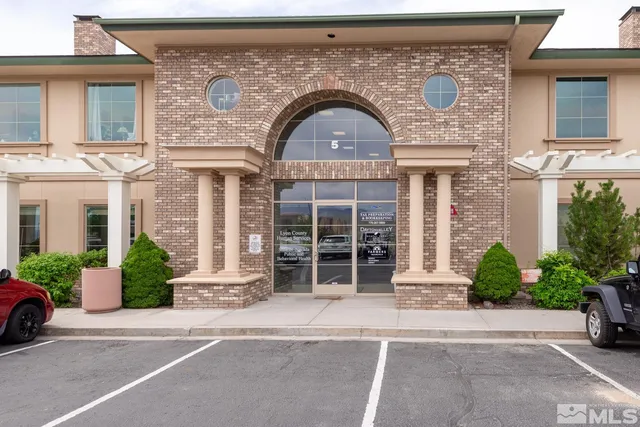front view of a brick house with a garden and plants