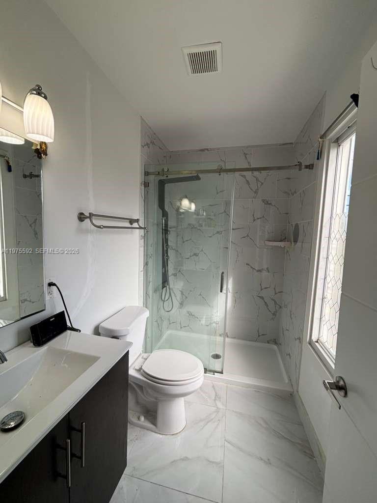 13900 Southwest 259th Street Homestead, FL 33032 - Photo 13 of 23 a bathroom with a granite countertop sink toilet and shower