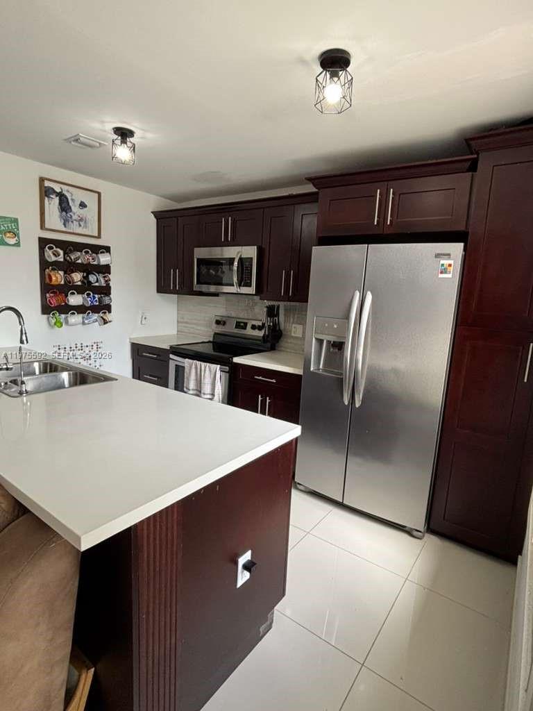 13900 Southwest 259th Street Homestead, FL 33032 - Photo 6 of 23 a large kitchen with kitchen island a refrigerator sink and stove
