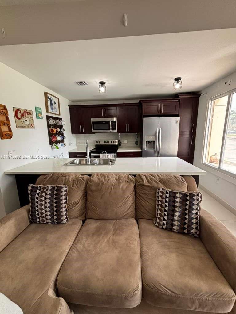 13900 Southwest 259th Street Homestead, FL 33032 - Photo 7 of 23 a living room with furniture a flat screen tv and kitchen view