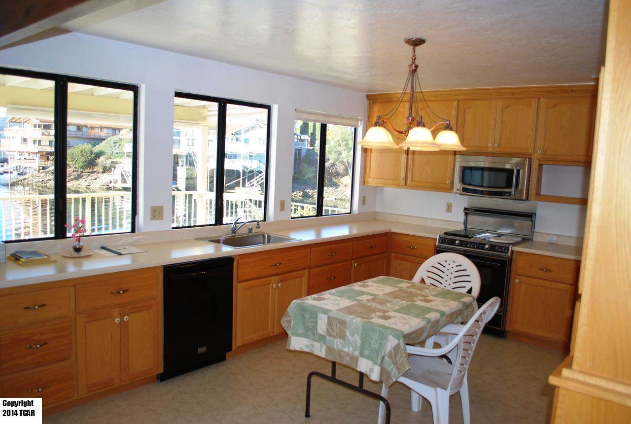 796 Mother Shipton Road Copperopolis, CA 95228 - Photo 6 of 24 a kitchen with a table chairs sink and microwave