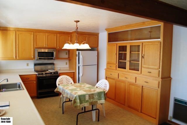 796 Mother Shipton Road Copperopolis, CA 95228 - Photo 7 of 24 a kitchen with a table chairs refrigerator and cabinets