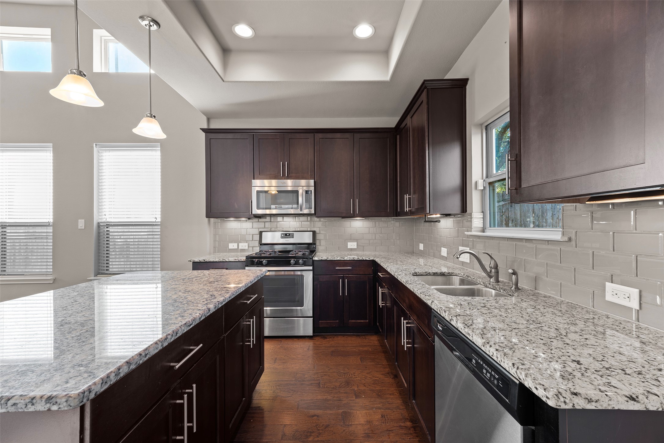 7233 Menchaca Road, Unit 2 Austin, TX 78745 - Photo 14 of 34 a kitchen with stainless steel appliances granite countertop wooden cabinets a sink dishwasher a stove and a refrigerator