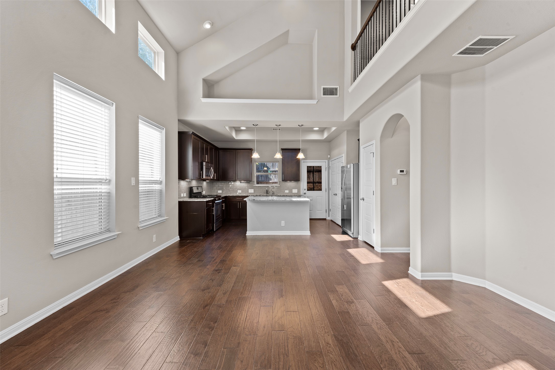 7233 Menchaca Road, Unit 2 Austin, TX 78745 - Photo 4 of 34 a large white kitchen with stainless steel appliances granite countertop a lot of counter space and wooden floor