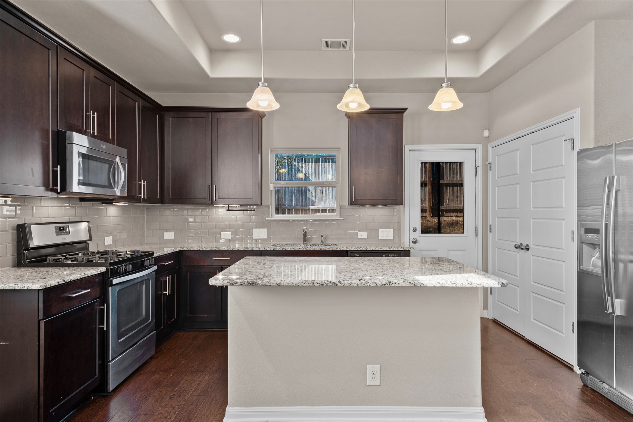 7233 Menchaca Road, Unit 2 Austin, TX 78745 - Photo 7 of 34 a large kitchen with stainless steel appliances granite countertop a sink a stove and a refrigerator
