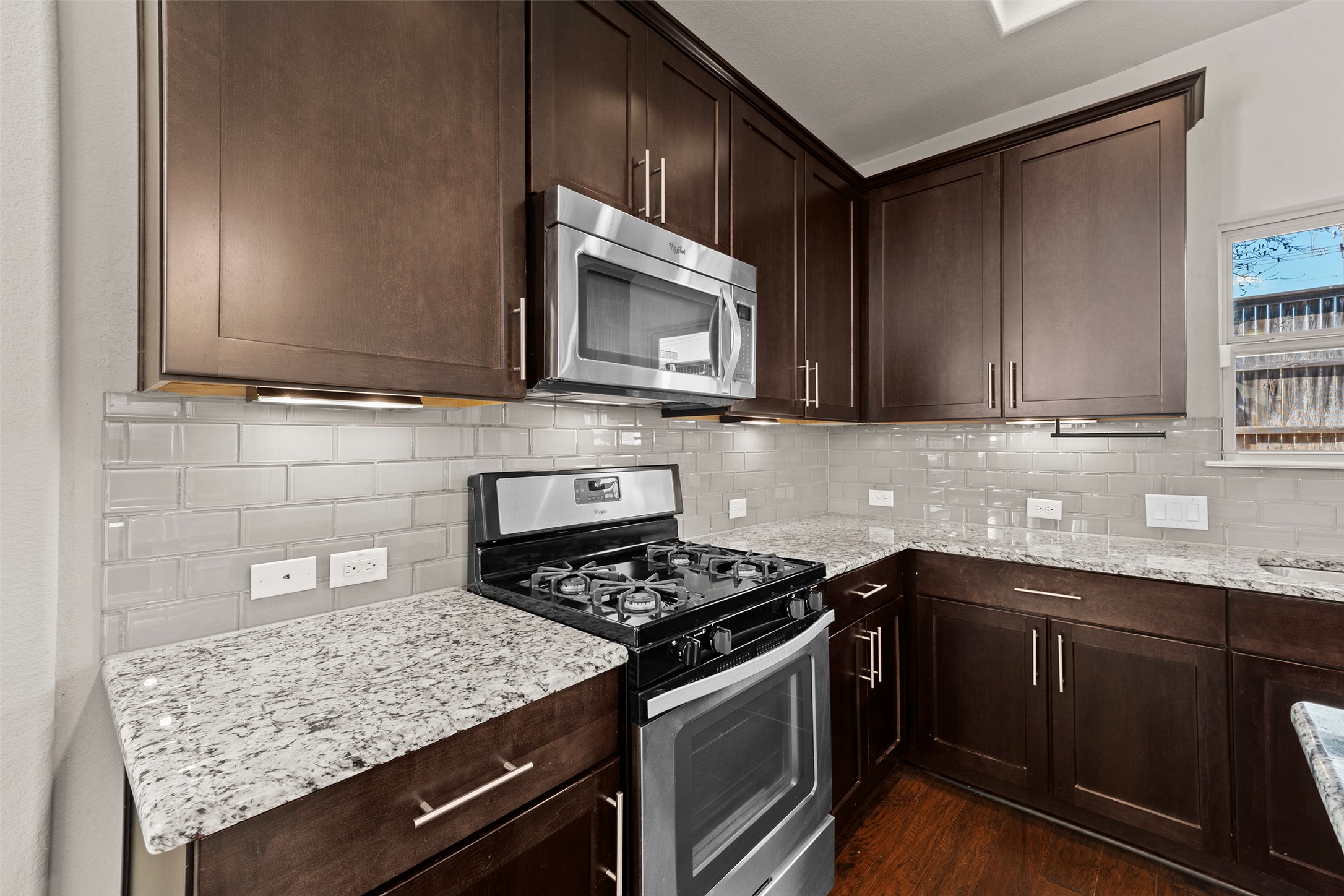 7233 Menchaca Road, Unit 2 Austin, TX 78745 - Photo 8 of 34 a kitchen with stainless steel appliances granite countertop a sink stove and microwave