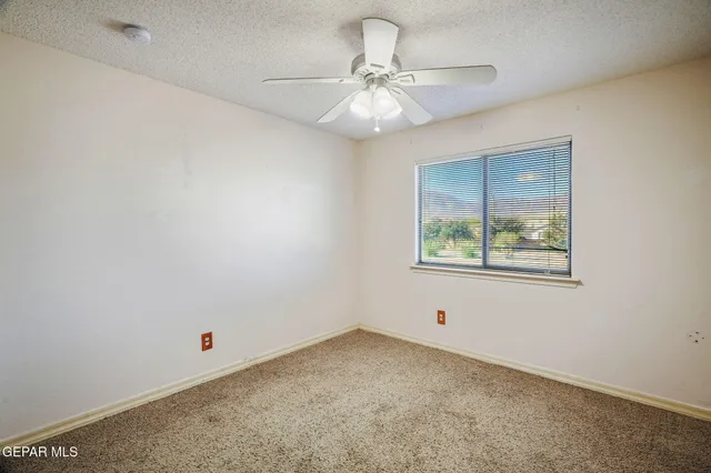 en empty room with window and ceiling fan