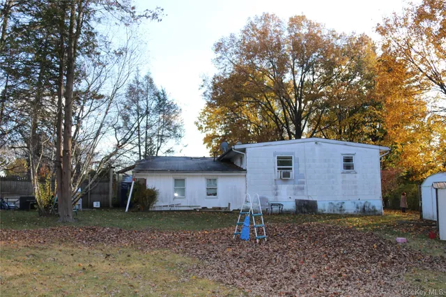 a view of a house with a yard and a large tree