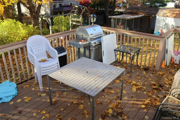 a view of a patio with table and chairs with wooden floor and fence